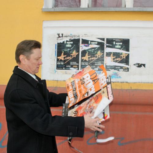 Депутат Чурсанов возмущен: рядом установлен специальный щит для рекламных объявлений, но все равно их клеят на стену дома. Фото автора